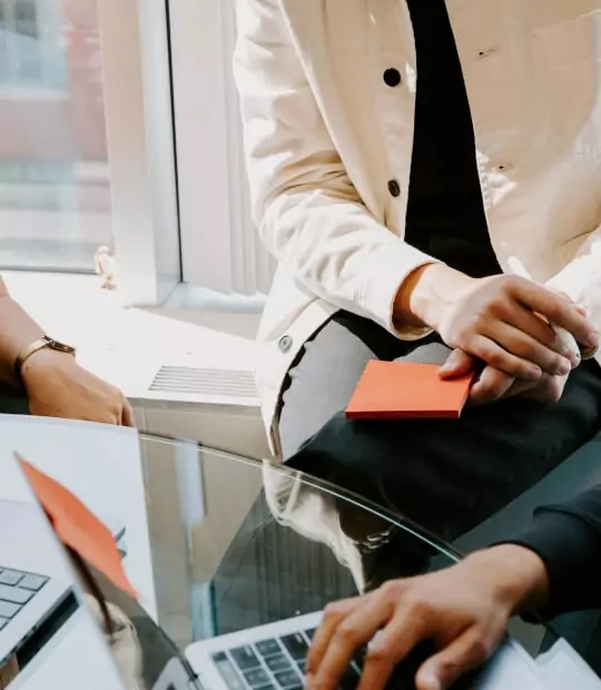 A group of people from a digital marketing agency sitting around a table with laptops.